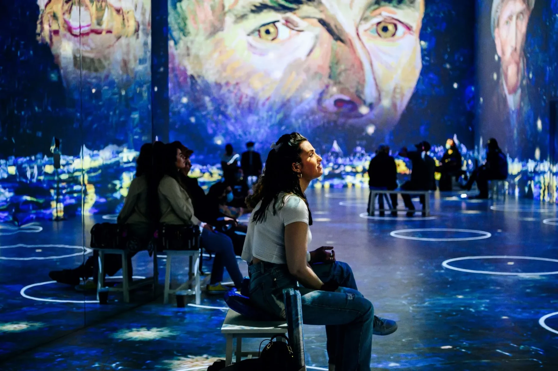 Visitor watching a large projected self-portrait