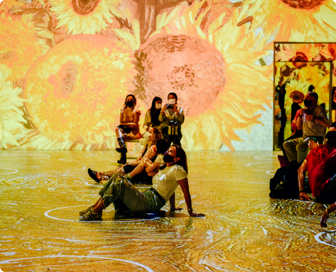 Guests relaxing in a room filled with projected sunflowers